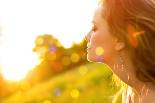 Young woman on field under sunset light